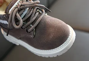 Détail de bottes pour enfants en daim marron avec doublure en fausse fourrure blanche épaisse
