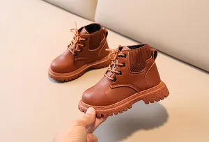 Close-up of brown leather kids boot with knitted ankle collar and thick anti-slip sole