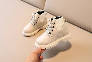 Close-up of children beige leather Martin boots with white knit ribbed cuffs and thick soles