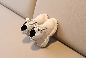 Detail of beige children's boots featuring knit collars and anti-slip rubber soles