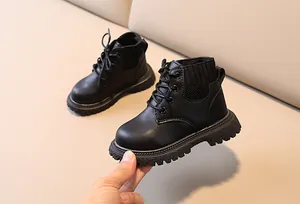 Detail view of black kids leather boots with knit ankle and thick non-slip rubber sole