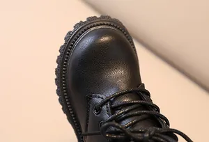 Close-up of black leather texture and durable stitching on children's martin boots
