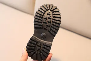 Close-up of anti-slip rubber sole with deep tread and size 28 marking on kids boots