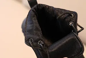 Detailed close-up of children's black Martin boots showing inner lining and metal eyelets