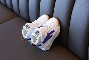 Detail view of kids mid-top sneakers with blue and red stripes on a textured leather sofa