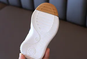 Detailed view of white anti-slip rubber sole with size marking and brown toe guard