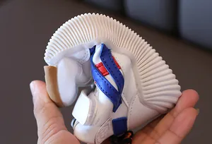 Highly flexible white children sneaker with anti-slip rubber sole folded in half