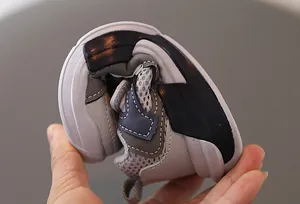 Vista de detalle de la suela blanda y flexible de zapato deportivo infantil siendo doblada