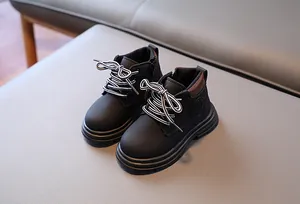 Détail de bottines noires pour enfants avec lacets rayés et fermeture éclair latérale