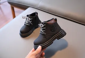 Détails des bottines noires mates pour enfants avec logo texturé et semelle en caoutchouc