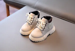 Détail de bottines enfant avec fermeture éclair, logo mode et semelle en caoutchouc