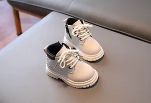 Détail de bottines enfant blanc cassé avec fermeture éclair et semelle antidérapante
