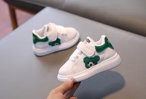 Detail of toddler sneaker with green plush bear motif and convenient velcro strap closure