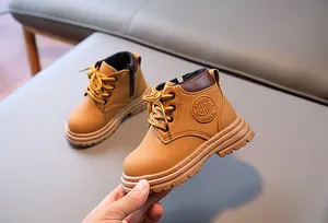Détail de bottines martin pour enfants jaunes avec fermeture éclair et semelle robuste