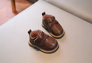 Dettaglio di scarpe per neonati in pelle marrone con velcro e suola in gomma morbida