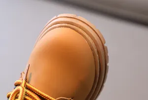 Gros plan des bottines jaunes pour enfants montrant le bout texturé et la couture