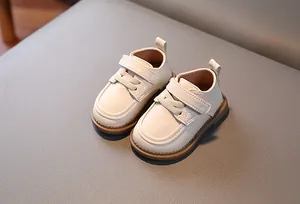 Vista dall'alto di scarpine da neonato in pelle crema con chiusura in velcro e punta tonda