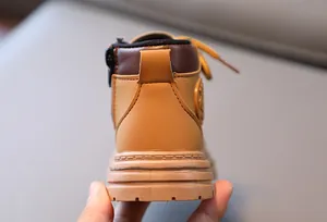 Détail de bottines d'extérieur jaunes pour enfants avec zip latéral et semelle antidérapante