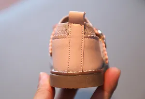 Gros plan de chaussures roses pour bébés montrant le tirant arrière et les bords festonnés