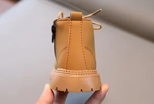Nahaufnahme gelber Kinderstiefel mit rutschfester Gummisohle und seitlichem Reißverschluss