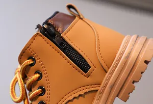 Détail de bottes en cuir jaune pour enfants avec fermeture éclair et coutures doubles