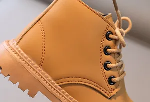 Nahaufnahme gelber Kinder-Martin-Boots aus Leder mit rutschfester Gummisohle und Nähten