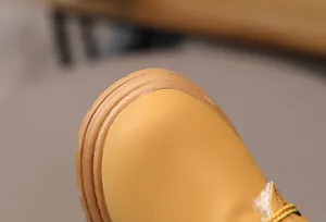 Close-up of yellow kids snow boots showing durable round toe and warm plush lining