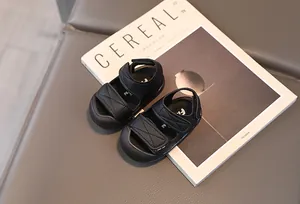Detail of baby closed-toe sandals featuring adjustable double velcro straps in black leather