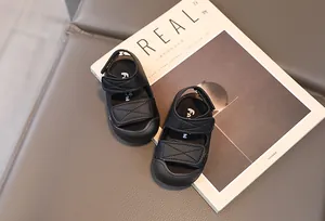Detail of black baby sandals with double hook-and-loop straps and closed protective toe