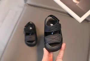 Detail of black toddler sandals featuring secure double hook-and-loop straps and closed-toe protection