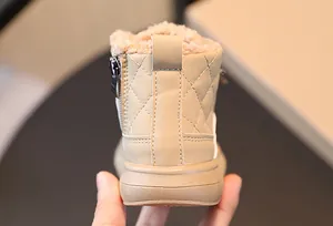 Dettaglio di stivali da neve beige per bambini con fodera in peluche e cerniera laterale