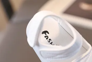 Detailed macro view of white baby leather sandals featuring soft inner sole and velcro strap