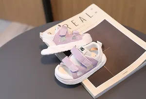 Detail view of purple toddler sports sandals with mesh fabric and velcro on a magazine