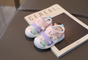 Close-up of baby sandals with colorful stitching, velcro straps, and cute rabbit patterns