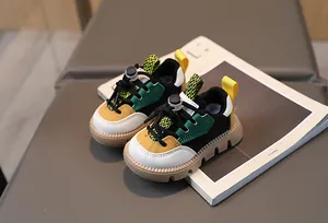 Detail of color-block kids sneakers showing multi-color panels and brown rubber sole