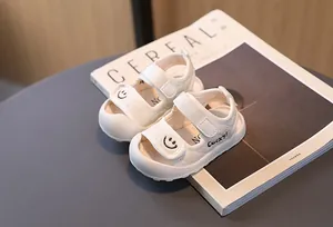 Dettagli di sandali bianchi per neonati con ricamo smiley e cinturini in velcro