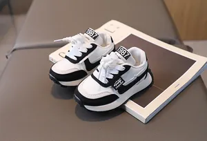 Detail of kids black and white sneakers with 1987 label and thick non-slip sole