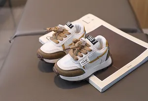 Detail of children's white and brown sneakers with elastic toggle laces and mesh fabric