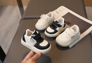 Détail de baskets pour tout-petits avec velcro et marquage sport en noir et blanc