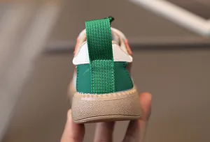 Detail shot of multicolor toddler sneaker heel with green pull tab and rubber sole