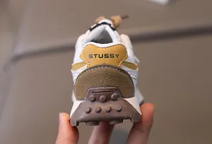 Detail of children's sneaker heel featuring rubber outsole and color-block leather