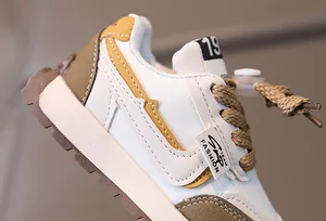 Detail of children's running shoe showing mixed material textures and drawstring laces
