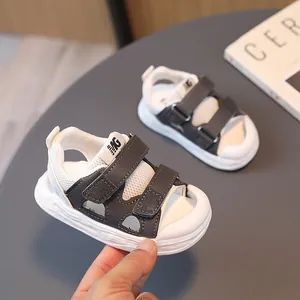 Toddler anti-kick sandals with mesh upper and hook-and-loop closure in black and white
