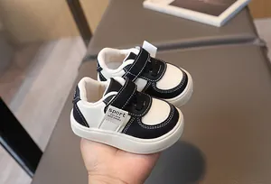 Détail de chaussures de marche pour bébé avec semelles souples et velcro en noir et blanc