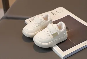 Détail de chaussures de marche crème pour bébé avec velcro sur surface en cuir