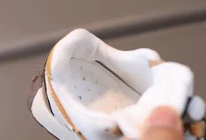 Detail view of breathable mesh lining and perforated insole of the children's sneaker