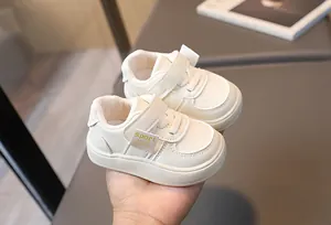 Détail de chaussures bébé crème avec fermeture velcro et perforations respirantes