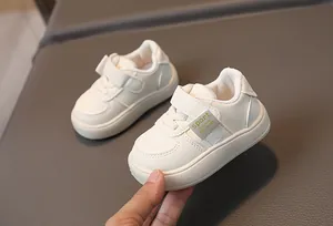 Vue détaillée de baskets blanches pour bébé avec fermeture velcro et cuir synthétique souple