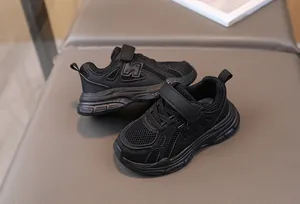 Detailed top view of black kids sneakers with breathable mesh and velcro strap closure