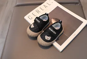 Detailed close-up of quilted black toddler shoes with bear embroidery on Cereal magazine